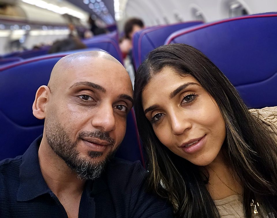 H and Dolly in their seats on a plane