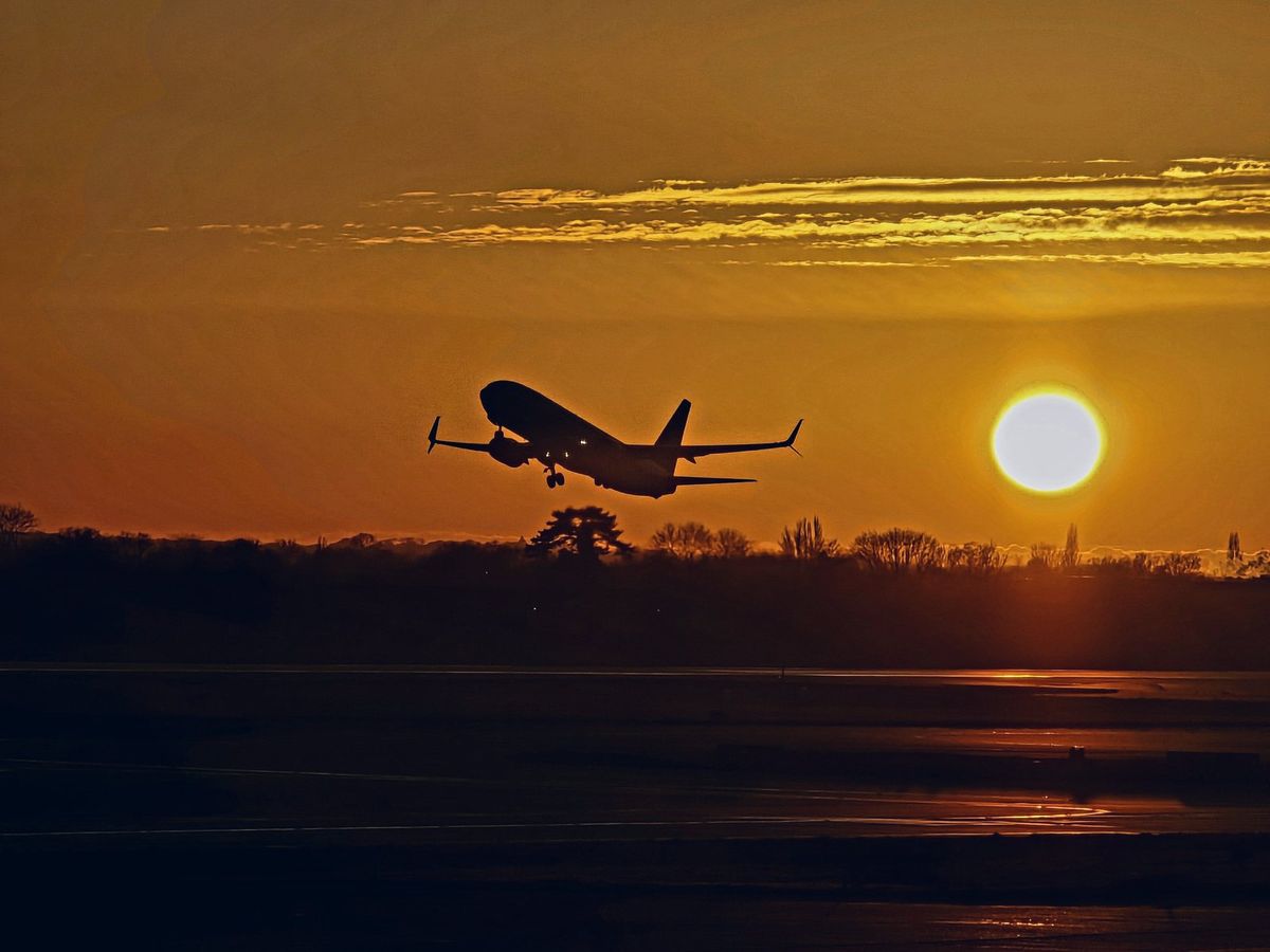 A plane taking off at sunset